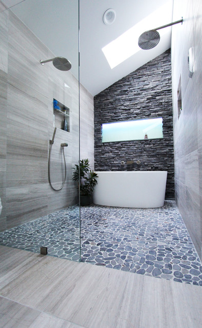 While this bathroom has a lot of tile going on, the open shower and tub seem to nestle together perfectly in it. This layout obviously isn't going for space saving, with the extended length and dual shower heads, but it's beautiful nonetheless.