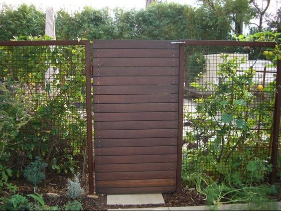 This modern wire fence checks all the boxes. The side metal inserts provide sight lines, the wood frame is minimal and doesn't draw the eye too significantly, and the horizontal wood fence gate with hidden hardware provides safety for #L2HQ. Fence #inspiration via www.L-2-Design.com