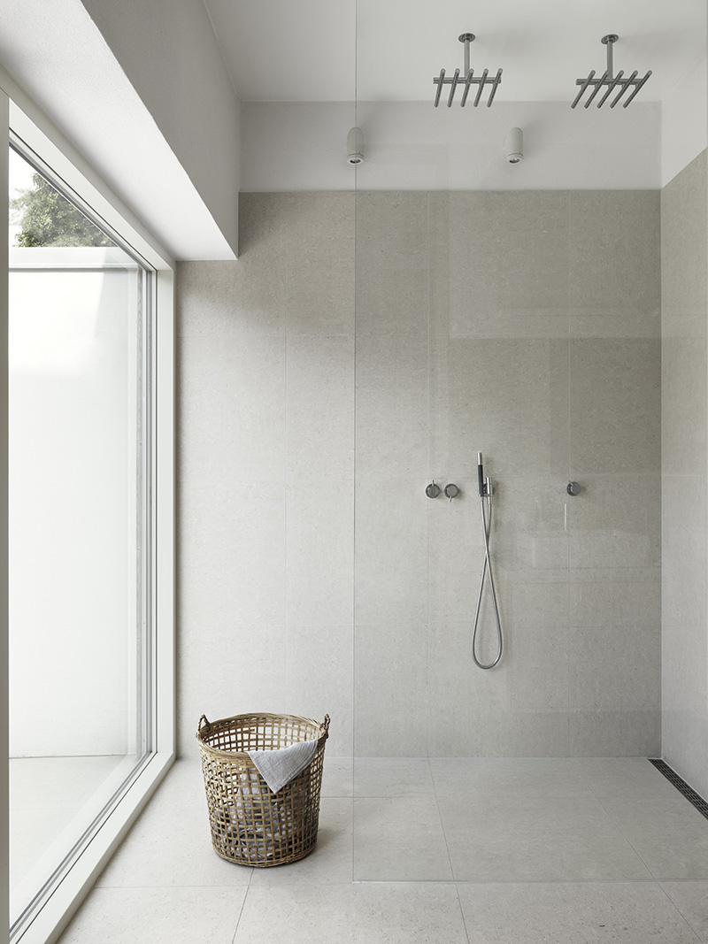 This beautiful, open bathroom continues to share light thanks to the glass divider that separates the walk-in shower from the rest of the space. 