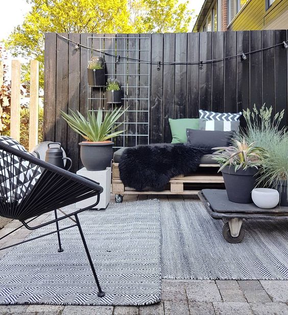 A look at a vertical fence design solution, this black stained fence provides great, modern privacy to the backyard seating. The simplicity of finish is reiterated in the furniture and decor of the seating area. Who wouldn't want to hang out there? #Backyard inspiration via www.L-2-Design.com