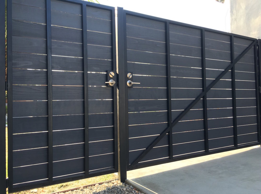 Bringing metal into the mix, this hinged modern fence gate combines the horizontal wood with a sturdy metal frame. #backyard inspiration via www.L-2-Design.com
