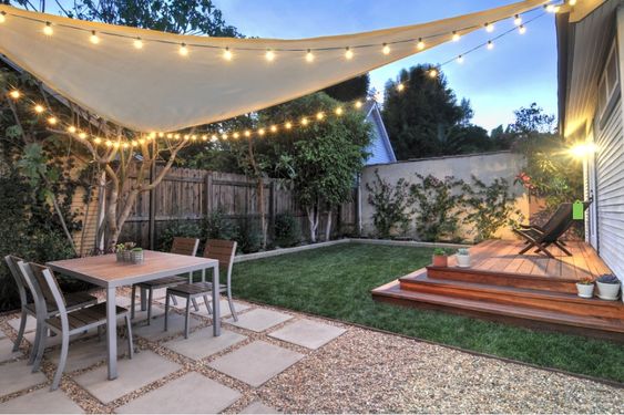How bohemian - this modern shade sail is paired with string lights to give a relaxed and fun evening feel to this backyard. #backyard inspiration via www.L-2-Design.com