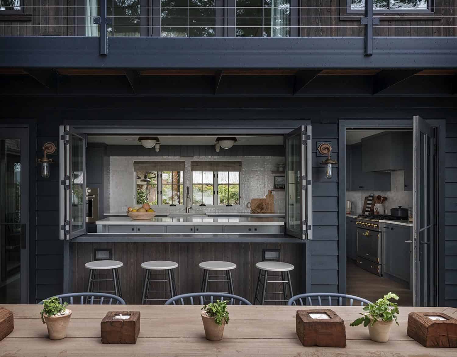 This indoor/outdoor kitchen has all the boxes checked: overhead coverage, barstools, accordion windows, clean lines, and great design. #backyard inspiration via www.L-2-Design.com